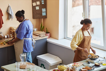 Portrait of two black young women cooking together while working in food delivery businessの写真素材