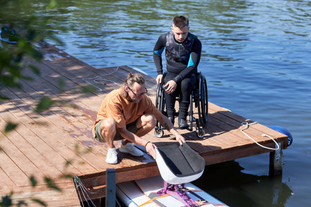Portrait of senior water sports instructor preparing adaptive wakeboarding equipment for man with...