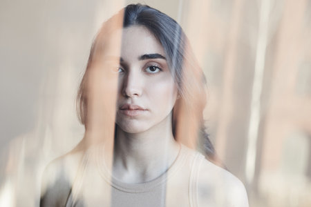 Distorted portrait of young woman struggling with mental health issues and looking at camera minimal