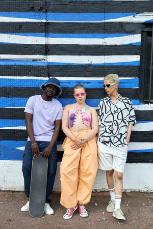 Full length portrait of multiethnic group of young people wearing trendy outfits posing as a band in urban settingの写真素材