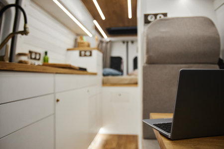Close up of open laptop on table at workstation in trailer van interior, copy spaceの写真素材