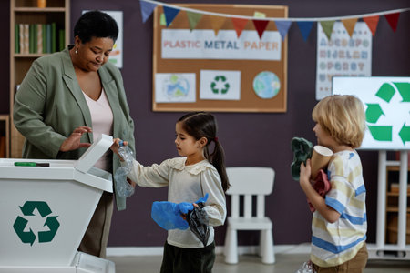 Side view portrait of little girl sorting plastic in recycling class at preschool, copy spaceの写真素材