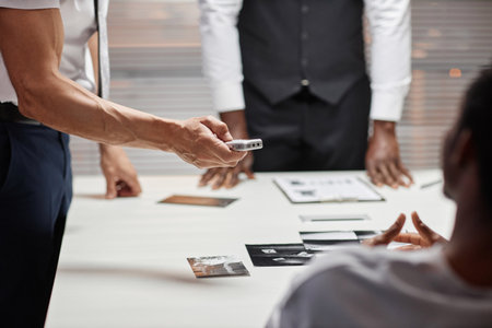 Close up of male detective holding voice recorder during interrogation of suspect, copy spaceの写真素材