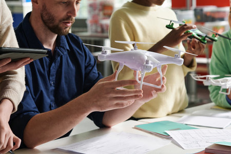Cropped image of course teacher launching Quadcopter with group of kidsの写真素材