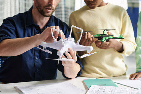 Cropped image of teacher showing schoolkid how to turn on Quadcopterの写真素材