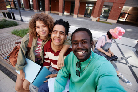 POV of three diverse young students taking selfie photo together on college campus and smiling at camera happilyの写真素材
