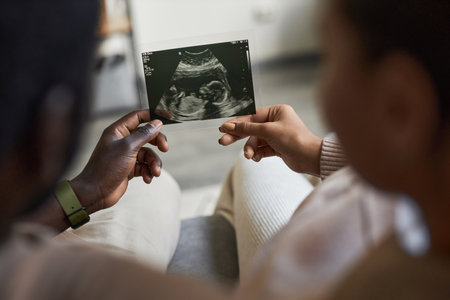 Close up of man and woman holding ultrasound picture together expecting baby, copy spaceの写真素材