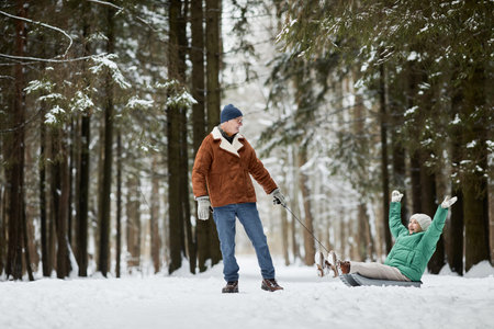 Joyful senior couple spending together in winter forestの写真素材