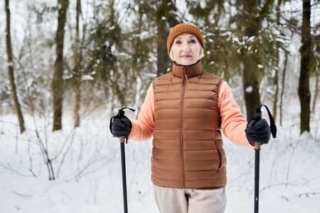 Portrait of senior woman skiing in city park on winterの写真素材