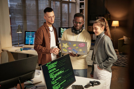 Group of software developers launching program on laptop to check how it works