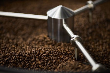Close up background image of green coffee beans spinning in coffee roaster, copy spaceの写真素材
