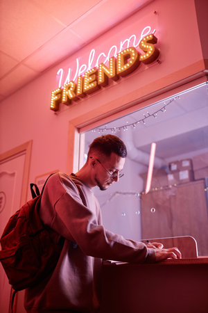 Side view portrait of young student signing in to register in hostel or college dorm, copy spaceの写真素材
