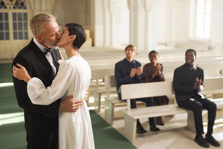 Side view portrait of loving senior couple in first kiss in church on wedding day, copy spaceの写真素材