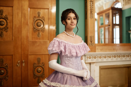 Waist up portrait of elegant young lady wearing pink ballgown looking at camera, copy spaceの写真素材