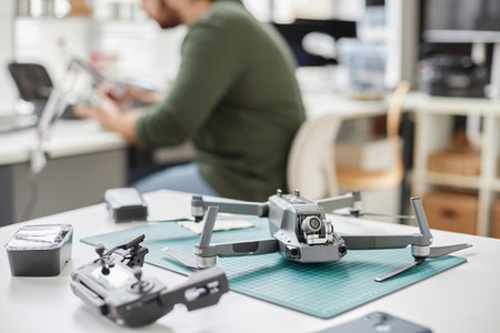 Close up of quadcopter drone with action camera on workstation in tech repair shop, copy spaceの写真素材