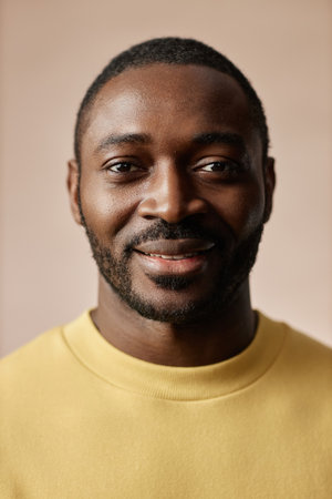 Minimal portrait of adult African American man looking at camera in studio against neutral backgroundの写真素材