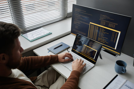 High angle closeup of adult man coding at office workplace working in IT development, copy spaceの写真素材