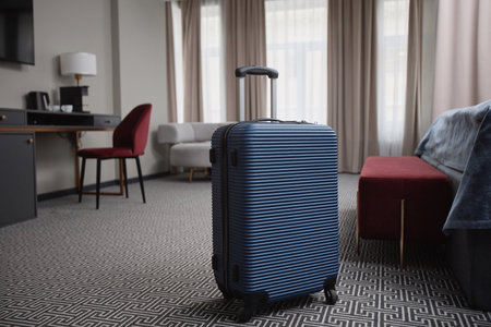 Background image of blue plastic suitcase on floor in luxury hotel room interior, copy spaceの写真素材