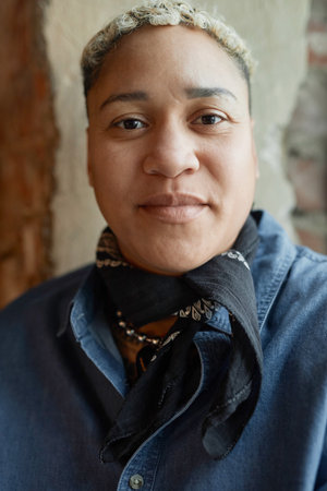 Vertical close up portrait of masc Black woman looking at camera with confidenceの写真素材