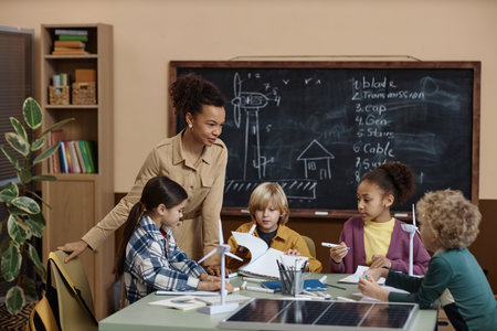 Diverse group of little kids with female teacher studying eco friendly energy in school classroom