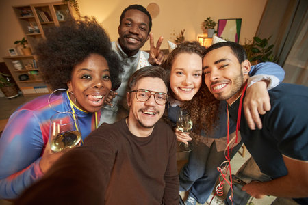 High angle portrait of cheerful adult friends huddling together and taking selfie photo at home...