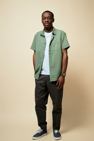 Vertical full length portrait o African American man wearing casual outfit with jeans posing in...