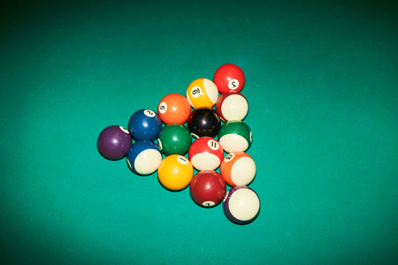 Minimal high angle view of billiard balls in triangle on green canvas table shot with flash copy...