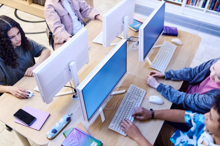 High angle view at group of children using computers in school library and doing research online