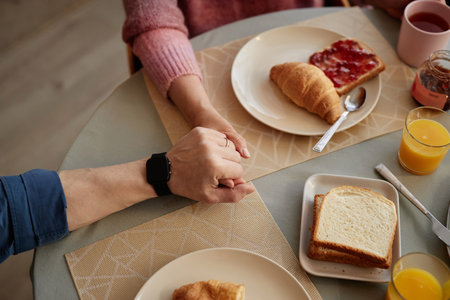 Top view closeup of senior couple holding hands at dinner table enjoying love in retirement copy...