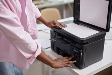 Close up of female hands of young contemporary office manager over printer copying documents, focus on scanner, copy spaceの写真素材