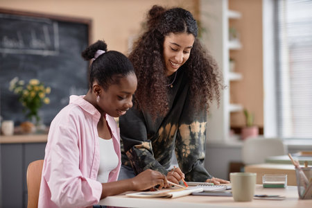 Happy high school multicultural students laughing while studying together in classroom, education concept, copy spaceの写真素材