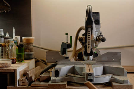 Well-organized woodworking station featuring an electric sawmill device and various tools neatly arranged on the workbench creating an efficient workspace for carpentry enthusiastsの写真素材