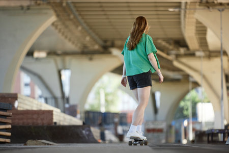 Exploring city by roller skating under urban bridge during warm summer afternoon, surrounded by...