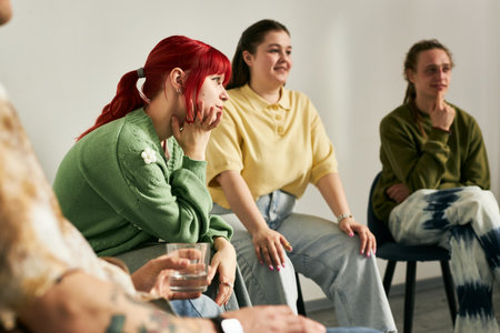 People engaging in a lively group discussion, sharing thoughts and experiences. Casual setting with participants seated, showing diverse expressions and attentive listeningの写真素材