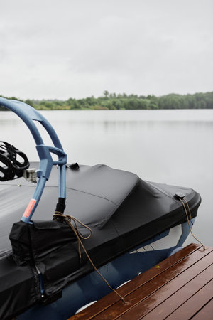 Vertical background image of motor boat covered with protective tent docked at pier with beautiful lake scenery no peopleの写真素材