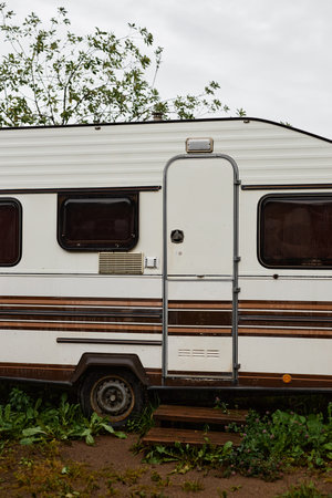 Vertical image of travelling van parked in rainy forest with door closed and no people copy spaceの写真素材