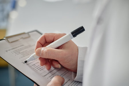 Side view of unrecognizable med college professor writing on clipboard and checking attendance in class, copy spaceの写真素材