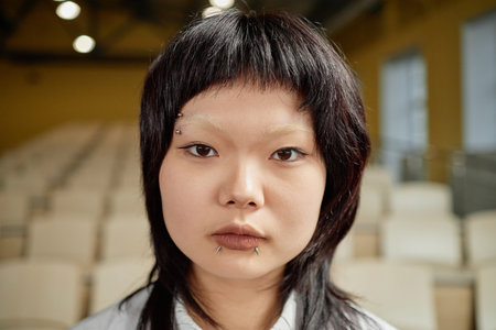 Vertical portrait of young Asian woman standing in classroomの写真素材