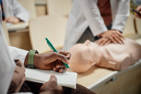 Closeup of female hands pressing on CPR mannequin during practical training session in university...