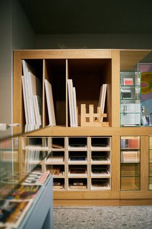 Wooden shelving unit featuring neatly organized books and documents. Open shelves and drawers displaying a variety of materials within a structured setupの写真素材