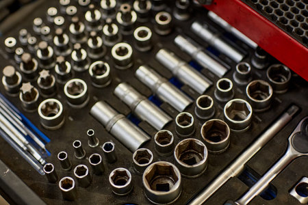 Neatly arranged mechanical tools in a toolbox offering various sizes and types of sockets along with ratchet wrenches and other instruments for mechanical repairsの写真素材