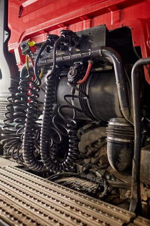 Detailed view of complex wiring and piping system inside a heavy-duty truck cab. Focus on coiled...