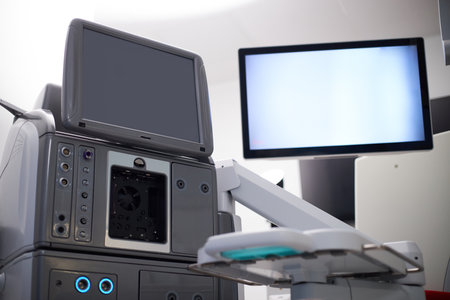 Medical equipment standing in operating room with large monitor and control panel visible, advanced surgical device positioned for use during medical procedure, no people presentの写真素材