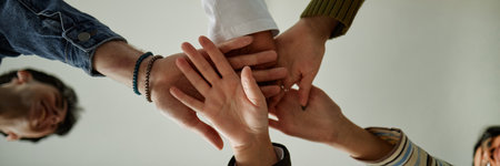 Diverse group of teenagers joining hands in teamwork gesture during counseling session, multiethnic boys and girls collaborating and supporting each other, unity and cooperation conceptの写真素材