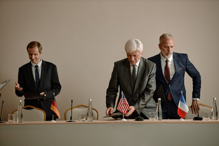 Three middle aged Caucasian men preparing for international meeting, standing behind conference...