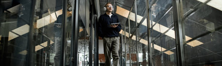 Website header shot of Caucasian young adult man walking through modern business office corridor...