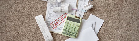 Hands holding invoices and bills with calculator on carpet, reviewing receipts and documents including past due notice, managing personal finances and expensesの写真素材
