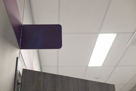 Empty hospital corridor ceiling showing blank purple sign above doorway in vascular center,...