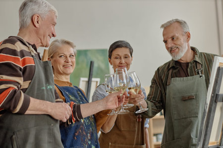Group of senior Caucasian men and women standing together holding wine glasses and smiling during...