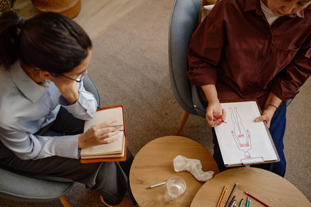 Middle aged woman holding clipboard with human body diagram discussing psychological concepts with...